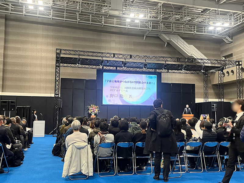 セミナー会場では、宇宙飛行士の野口氏がG空間社会についての講師をされていました。 椅子は満席で立ち見されている方もたくさんいらっしゃいました。